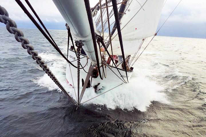 Ein Segelschiff fährt bei rauer See auf die Kamera zu