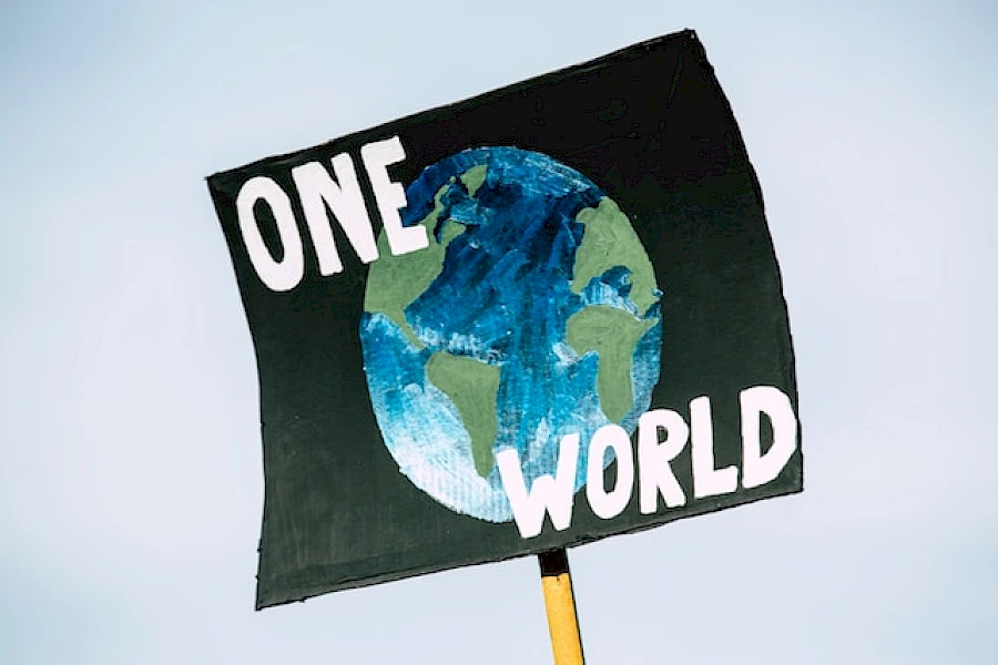 Demoschild mit Abbildung der Erde und Schriftzug "One World"